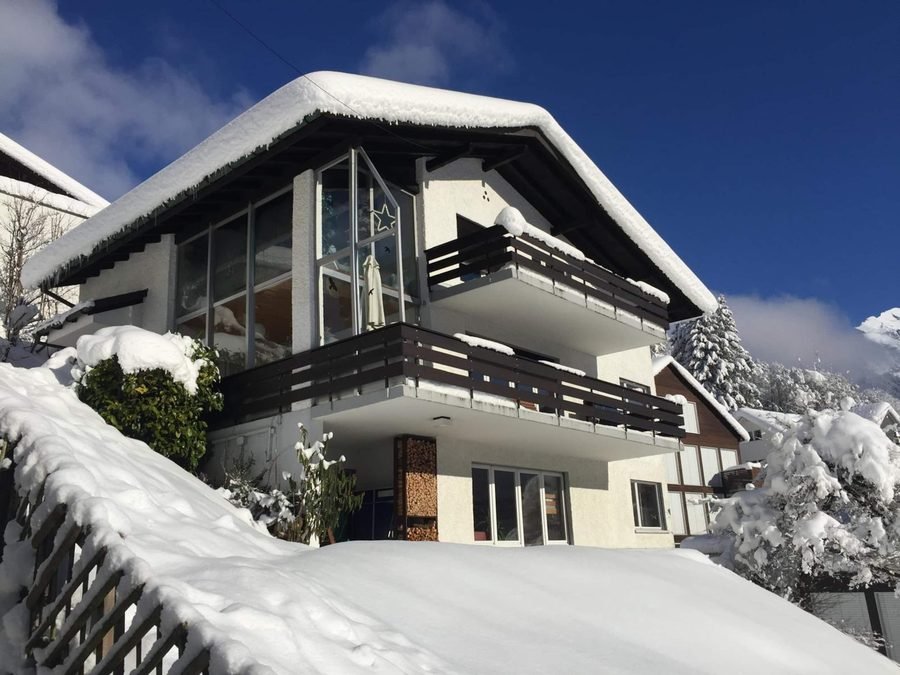 The house under deep snow with blue sky, the flat on the ground floor